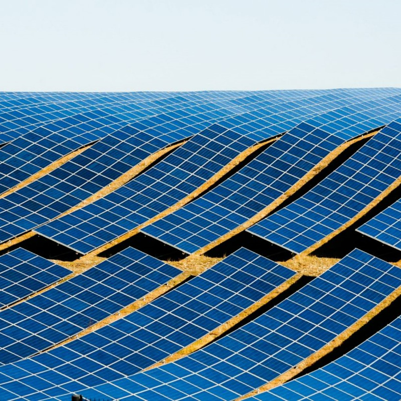 Challenges to investmentIndia's energy transition presented an opportunity to strengthen the local economy in the renewable energy (RE) sector. Despite the nascent state of the renewable energy industry in the early 2000s, one of India’s national goals was to support domestic companies and enhance local manufacturing capacity. If policies helped to create new jobs, the government expected public support for renewable technologies to be increased. Moreover, India sought to spur new innovations and level the competition between domestic and international manufacturers who dominated the renewable energy industry, potentially catalyzing a cost-effective domestic supply chain in the long run.ApproachIn 2009, India launched the Jawaharlal Nehru National Solar Mission, or the National Solar Mission (NSM), which, among other goals, aimed to establish a domestic manufacturing industry for solar energy. The initiative sought to reach a 4-5 GW equivalent of installed annual manufacturing capacity by 2020. To achieve this goal, the government enacted local-content requirements (LCR) for select solar technologies, which would be phased in over time. During Phase I of the program (2010-12), the enforced LCRs only applied to crystalline silicon technologies. In Phase II (2013-17), project developers needed to procure locally made solar photovoltaic (PV) to participate in the domestic content requirement (DCR) auctions held under the NSM. Alternatively, developers could enter open auctions that did not have LCRs, or they could participate in both DCR and open auctions by submitting separate bids. In 2018, the Ministry of New and Renewable Energy (MNRE),the nodal body for renewable energy in India, issued orders to implement “Make in India” rules for the public procurement of clean power in India. It required a 100% local content requirement for solar modules in grid-connected plants and 70% for off-grid/ decentralized solar projects for all projects tendered by the federal government, ministries and public sector undertakings.Key Enabling ConditionsThe NSM was accompanied by other solar initiatives and programs jointly creating a market for solar energy and its development. For instance, the following Make in India policy in 2018 aimed to continue the initial success by fostering the environment for domestic solar manufacturing.Impact / OutcomesDuring Phase I, India's manufacturing capacity for crystalline silicon modules grew by 135%, partly due to LCRs. Extending the LCRs to thin-film products in DCR auctions in Phase II, the construction of crystalline silicon module-making capacity accelerated further, increasing by 27% per year, compared to 9% annually in Phase I. However, solar panels procured under LCRs between 2014-17 were about 14% more expensive than imported PV modules, resulting in a cost increase of around 6% per kWh. This additional expense added between USD 69 million and USD 88 million per installed GW of solar PV under the LCRs. Still, the LCRs in this period helped to spur innovation, resulting in a significant rise in new patent applications from Indian entities. Between 2014 and 2018, India’s solar production capacity grew from 0.2 GW to 0.8 GW, while the installed solar power generation capacity expanded from 3.3 GW to 28.9 GW. LCRs have played a significant role in the 135% growth in the manufacturing capacity of crystalline silicon modules in phase 1. After the “Make in India” announcement, domestic manufacturers expressed significant confidence in ramping up their manufacturing capacities. As of 2022, India had an installed PV cell manufacturing capacity of 3 GW/year and a PV module capacity of 10 GW/year.Additional SourcesBazilian, M., Cuming, V., &amp; Kenyon, T. (2020). Local-content rules for renewables projects don't always work. Energy Strategy Reviews, 32, 100569, https://doi.org/10.1016/j.esr.2020.100569 Hansen, U. E., Nygaard, I., Morris, M., &amp; Robbins, G. (2019). Local content requirements in auction schemes for renewable energy: Enabler of local industrial development in developing countries? UNEP DTU Partnership Working Paper Series 2019 No. 2, https://backend.orbit.dtu.dk/ws/portalfiles/portal/193202331/Effects_Local_Contents_WEB.pdf Johnson, O. (2013). Exploring the effectiveness of local content requirements in promoting solar PV manufacturing in India (No. 11/2013). Discussion Paper, https://unctad.org/system/files/non-official-document/DITC_TED_13062013_Study_GDI.pdf Probst, B., Anatolitis, V., Kontoleon, A. et al. (2020). The short-term costs of local content requirements in the Indian solar auctions. Nat Energy 5, 842–850, https://doi.org/10.1038/s41560-020-0677-7 https://www.pv-magazine-india.com/2019/02/07/government-prioritizes-indian-products-in-plan-for-12-gw-of-new-solar/ https://www.pv-magazine-india.com/2020/08/21/manufacturers-want-50-basic-customs-duty-on-solar-imports/ https://www.pv-magazine-india.com/2020/09/11/local-content-requirement-costs-for-large-scale-pv-in-india/ 