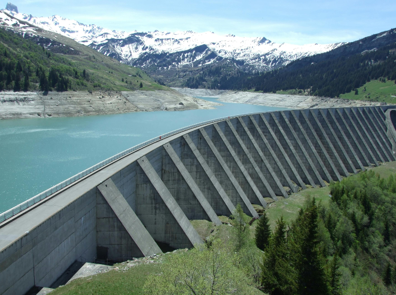 Solar–hydro hybrid systems combine photovoltaic (PV) generation with hydropower to deliver more stable and flexible renewable electricity. Floating PV arrays installed on hydropower reservoirs use existing surface area and benefit from water-based cooling, which can improve panel performance and avoid land-use impacts while potentially reducing water evaporation in suitable climates. Solar PV provides efficient daytime output, while hydropower offers controllable generation that compensates for rapid changes in sunlight, supports evening peaks and maintains supply during cloudy or seasonal variations. By leveraging the complementary operating profiles of both technologies, hybrid systems can increase renewable utilization, reduce reliance on thermal backup and enhance the operational flexibility of existing hydropower assets. Digital control platforms further optimize the interaction between PV output, hydropower regulation and grid requirements to smooth variability, coordinate ramping and support system reliability in regions with high shares of solar generation.&nbsp;The International Renewable Energy Agency (IRENA) notes that hybridizing hydropower with solar PV improves system operation across multiple time scales, reduces curtailment and increases transmission utilization.[1]&nbsp;Additional benefits are possible when hydropower is paired with battery energy storage to expand operating range and enhance grid flexibility.&nbsp;Main outcomes of the solution&nbsp;Sustainability: Enables additional solar generation without requiring new land and can reduce water evaporation on reservoirs in favorable climates; complementary operation lowers reliance on fossil-based backup and supports broader decarbonization efforts.&nbsp;Reliability &amp; Flexibility: Improves balancing capability by using hydropower to stabilize variable solar output across daily and seasonal cycles, enabling more predictable renewable dispatch.&nbsp;&nbsp;System Resilience: Leverages hydropower’s fast-response capability to manage solar fluctuations and maintain stability during weather-related variability or demand spikes, while making better use of existing grid and hydropower assets.&nbsp;Key deployment and scaling factors&nbsp;Assess site suitability for solar–hydro hybridisation by analysing local solar resources, hydropower operating profiles, hydrological constraints and demand patterns.&nbsp;Deploy unified control platforms to coordinate real-time interaction between PV output, hydropower regulation and grid requirements.&nbsp;Define clear operating strategies for joint dispatch so that both resources contribute optimally across different times of day and seasons.&nbsp;Establish supportive regulatory and commercial models that recognise hybrid-system benefits such as higher renewable utilisation and reduced curtailment.&nbsp;Adapt grid-connection and protection settings to meet technical requirements including voltage, frequency, ramp-rate and disturbance performance.&nbsp;Conduct environmental and reservoir-engineering assessments for floating PV, including mooring design, reservoir ecology and water-use impacts.&nbsp;Coordinate with hydropower operators to align hybrid operation with flood-control, irrigation and water-management obligations.&nbsp;Case Study&nbsp;The Electricity Generating Authority of Thailand (EGAT) and Siemens (2021), Thailand&nbsp;Commissioned in 2021, the Sirindhorn Dam project in Thailand is one of the world’s largest hydro–floating solar hybrid installations. The Electricity Generating Authority of Thailand (EGAT) integrated a 45 MW floating solar PV array with the existing 36 MW hydropower plant, enabling coordinated output from both resources. The floating PV panels cover part of the reservoir surface, allowing power generation without new land requirements. Siemens provided digital control and energy-management software, which forecasts solar and hydropower production, manages joint power dispatch and coordinates the combined output based on weather conditions, reservoir management needs, and grid requirements.&nbsp;According to EGAT, the project configuration enhances clean-energy production, supports national decarbonization goals, and serves as a model for maximizing the value of existing hydropower infrastructure through hybridization. The project is expected to reduce CO₂ emissions by around 47,000 tons/year. The project demonstrates how digital control systems can improve renewable utilization and deliver stable output from variable solar resources.[2,3]References:The changing role of hydropower I IRENA (2023)&nbsp;&nbsp;The World’s Largest Hydro-Floating Solar Hybrid I EGAT (July 2021)&nbsp;EGAT deploys Siemens’ software solutions for the world's largest Hydro-Floating Solar Hybrid Project I Siemens (January 2022)&nbsp;