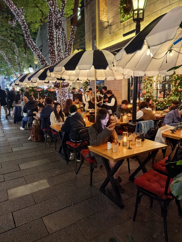 Shanghai, as a global metropolis, faces the challenge of balancing commercial vibrancy with urban management. Outdoor dining (外摆位) has historical roots in Shanghai, but traditional strict traditional restrictions have constrained business vitality. In December 2022, Shanghai amended its Municipal Appearance and Environmental Sanitation Regulations, changing the wording from "prohibited" to "prohibited without authorization," which opened new possibilities for regulated outdoor dining. Since then, Shanghai has been continuously refining policies and service ecosystems, exploring efficient governance models to boost the nighttime economy.